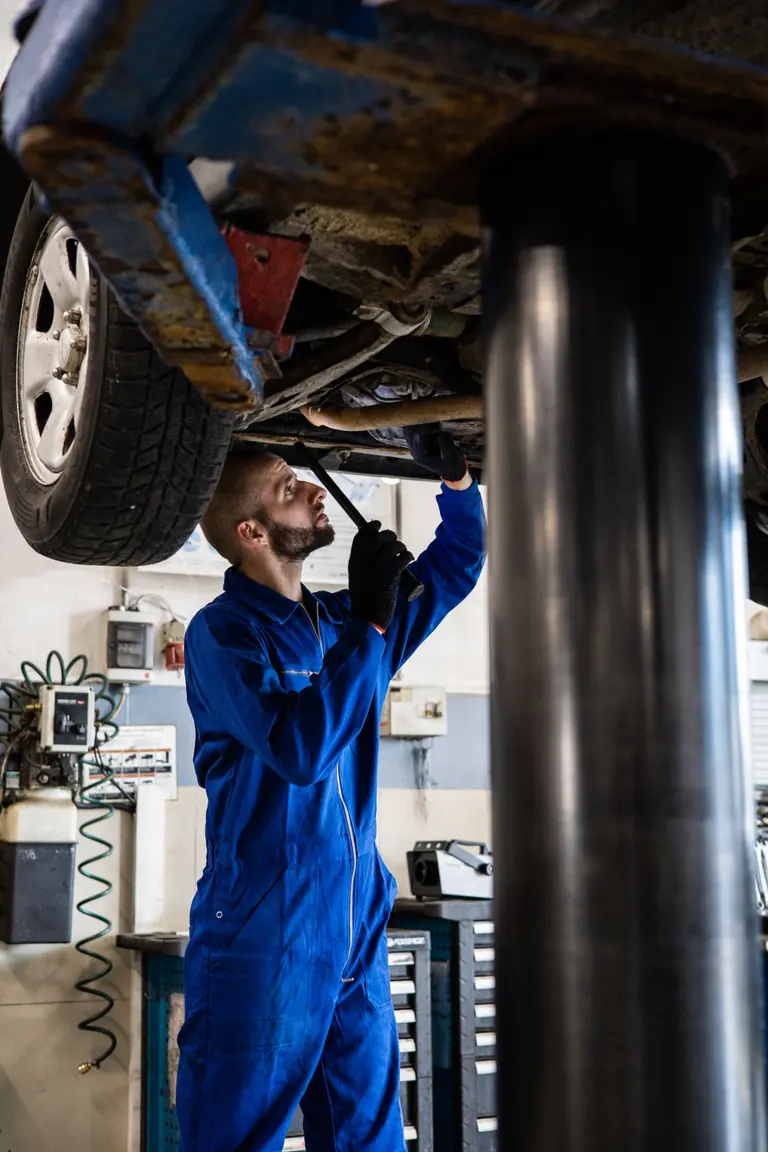 Mechanik sprawdza podwozie samochodu na podnośniku